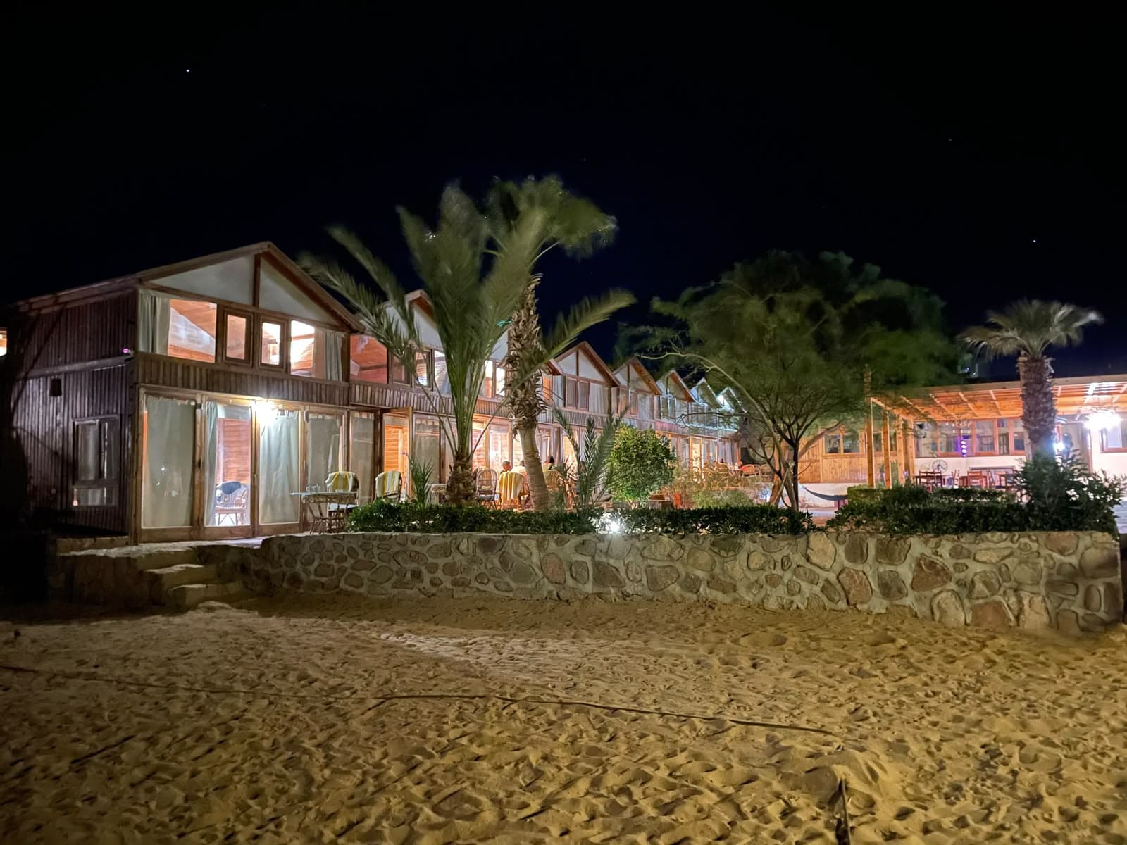 Illuminated wooden chalets at night on the sand